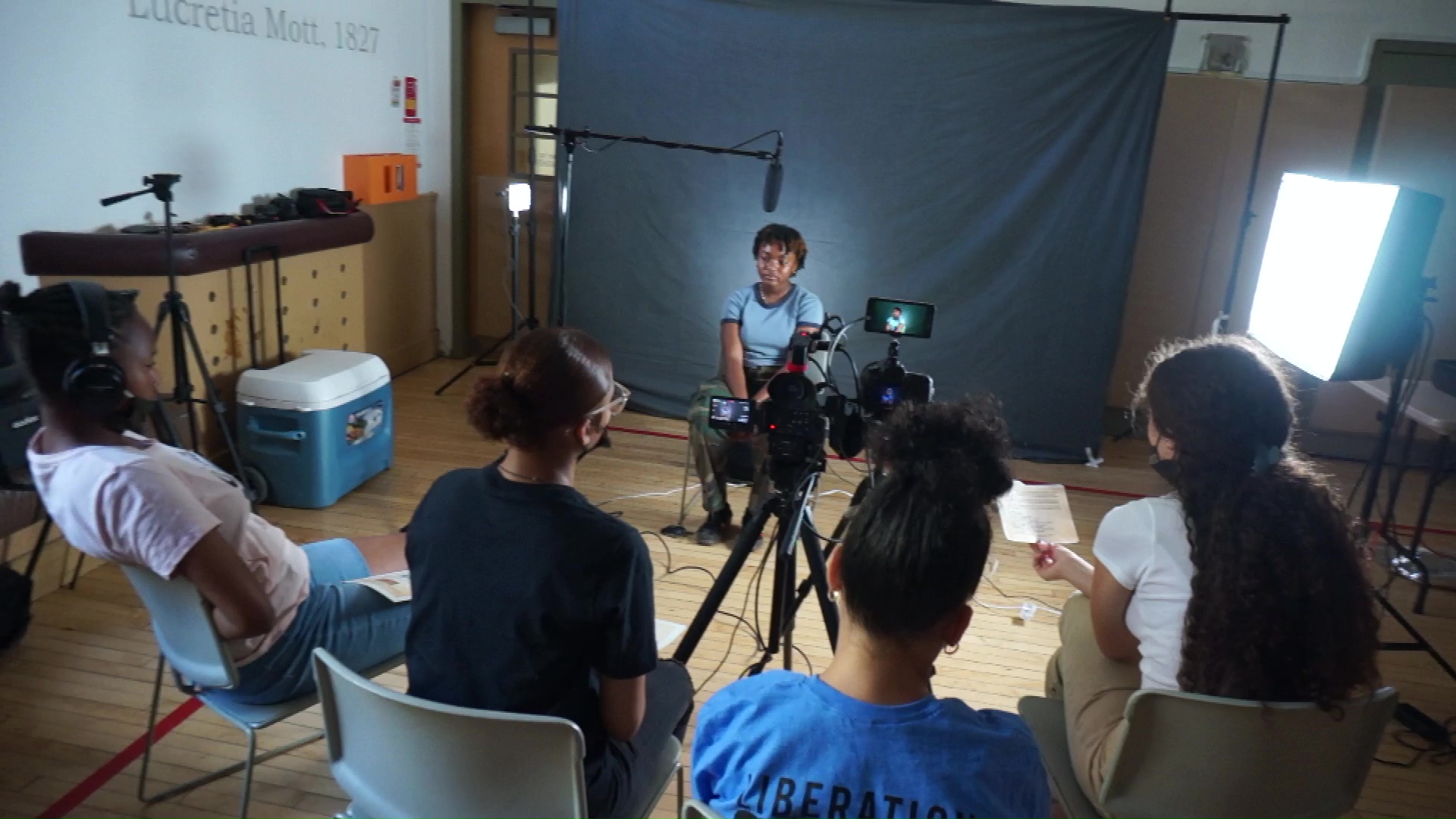 Four youth interviewing someone in a studio