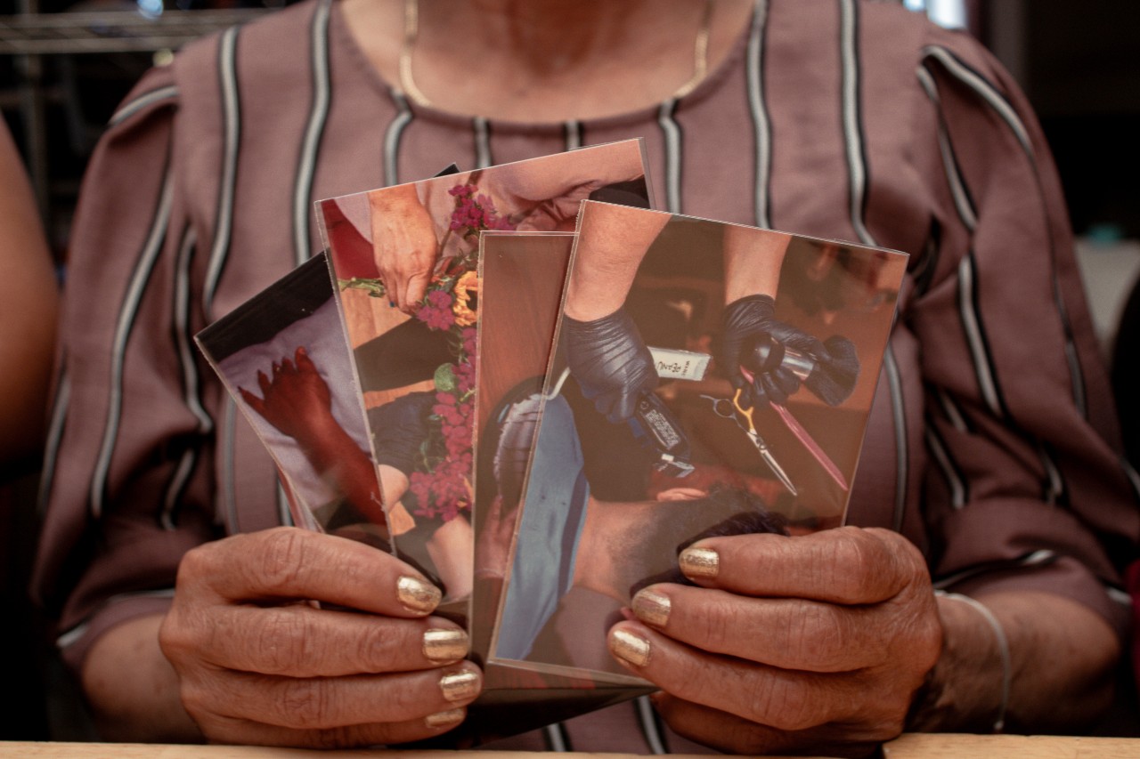 Closeup of woman's hands holding photos of haircutting
